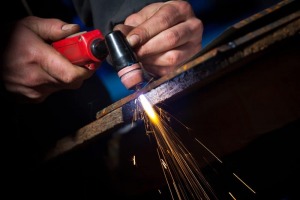 man cutting a metal